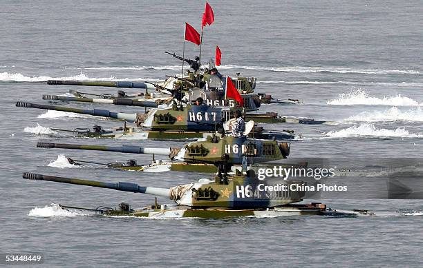 Amphibious tanks of the Chinese People's Liberation Army move to land a beach during the second phase of the Sino-Russian joint military exercise on...