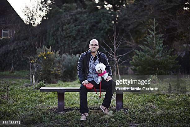 mixed race early 30's male sat with his dog - chinese crested dog stock pictures, royalty-free photos & images