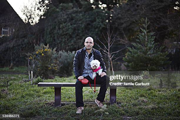 mixed race early 30's male sat with his dog - cão chinês de crista imagens e fotografias de stock