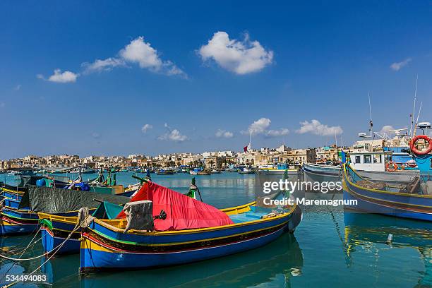 the port with the typical boats and the village - marsaxlokk stockfoto's en -beelden