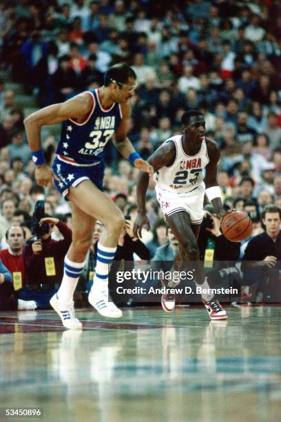 Michael Jordan of the Eastern Conference All-Stars brings the ball upcourt against the Kareem Abdul-Jabbar of the Western Conference All-Stars during...