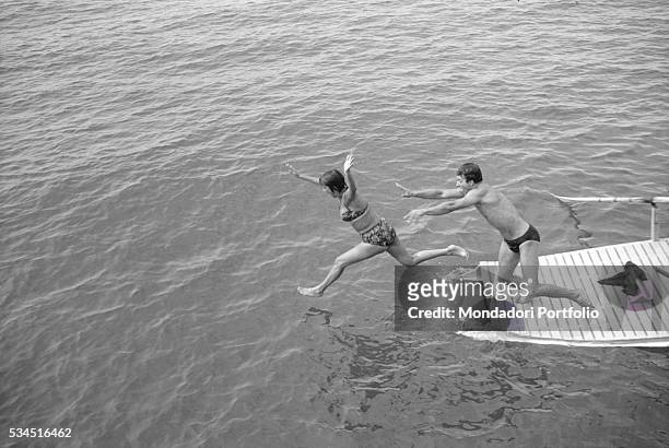 Italian actor Franco Interlenghi and his wife, Italian actress Antonella Lualdi, diving from a boat during the XVIII Venice International Film...