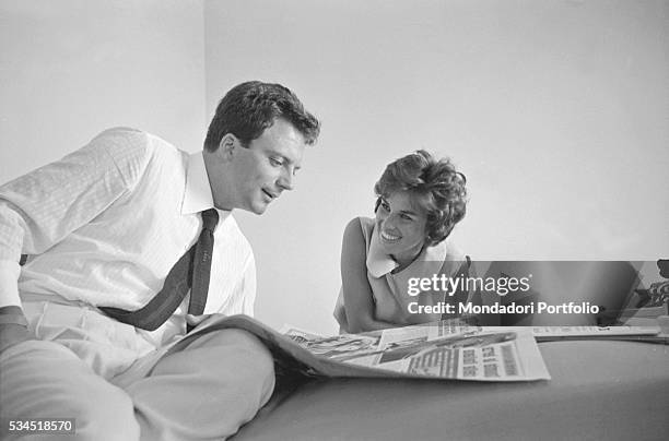 Italian actress Antonella Lualdi looking at her husband and Italian actor Franco Interlenghi reading a newspaper during the 19th Venice International...