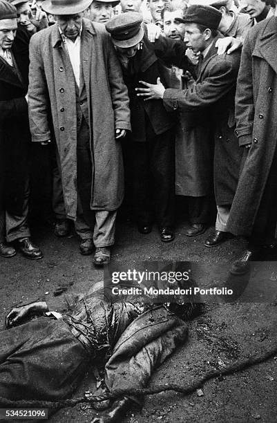Insurgents watcing the corpse of a colonel of the Hungarian secret police dead during the clashes. Budapest, November 1956