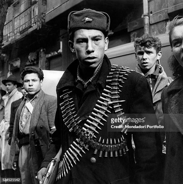 Young rebel with two cartridge belts loaded with bullets taking part in the Hungarian Revolution of 1956. Budapest, November 1956