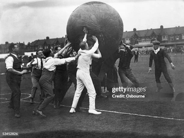 An LCC game of pushball at Leyton, during which the two teams try to push a leather-covered ball, six feet in diameter, across their opponents' goal,...