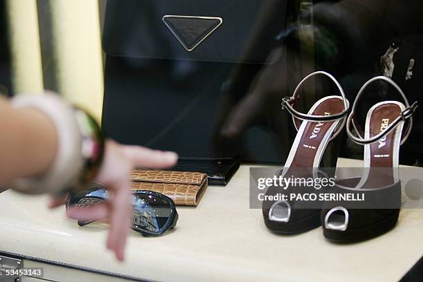 Una mujer observa una vidriera de una zapateria el 23 de agosto de 2005 en Roma. La prestigiosa industria del calzado italiana se ve confrontada hoy...