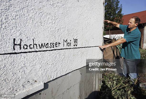 Helmut Koelbl points to a line showing the height of the floodwaters in May 1999 and with his right hand points to the level of the water in the...