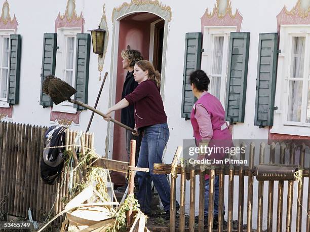 Woman shovels mud outside of a house on August 24, 2005 in Eschenlohe, Germany. People in southern Bavaria are cleaning up the streets and their...