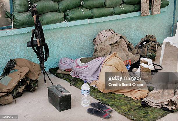 Marine Pfc. Thomas Calamita, from Buffalo, New York, serving with India Company 3rd Battalion 25th Marine Regiment, sleeps on the patio of a home...