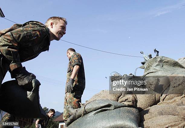 German soldiers remove sandbags from a flood barrier on August 24, 2005 in Eschenlohe, Germany. People in southern Bavaria are cleaning up the...