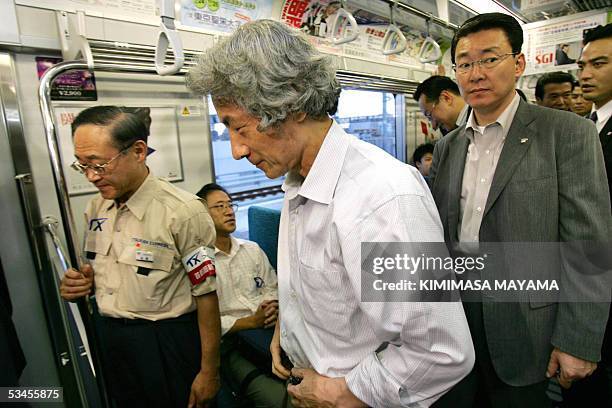 Japanese Prime Minister Junichiro Koizumi talks with passengers as he takes a ride on a car during an inspection of a new commuter line Tsukuba...