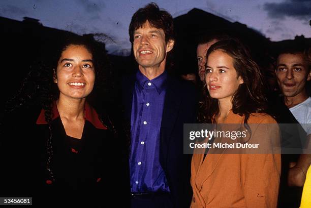 Musician Mick Jagger of The Rolling Stones poses with his daughters Karis and Jade in 1995 in Paris, France.