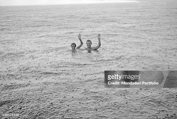 Italian actor Franco Interlenghi and his wife, Italian actress Antonella Lualdi , waving hands in the sea under the rain during the XVIII Venice...