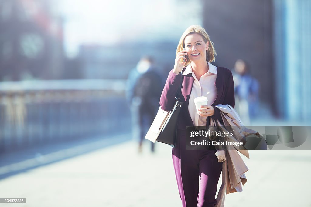 Businesswoman talking on cell phone on city sidewalk