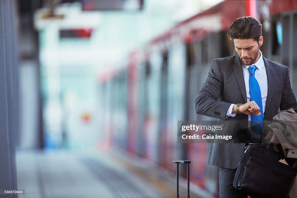 Businessman checking his watch in train station