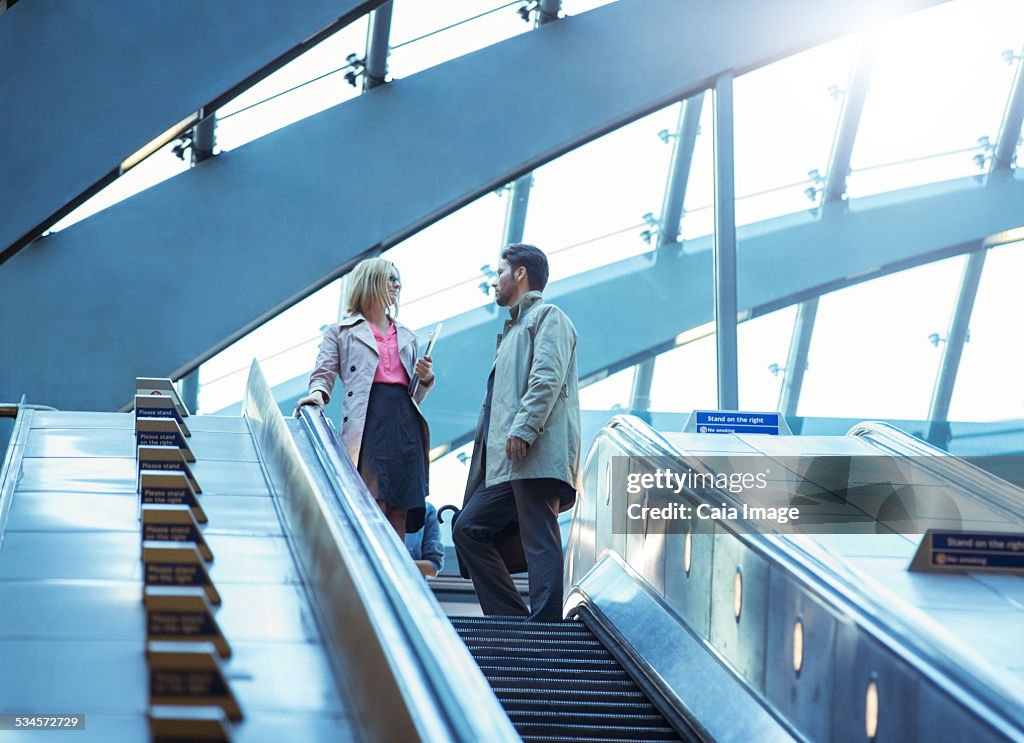 Business people riding escalator