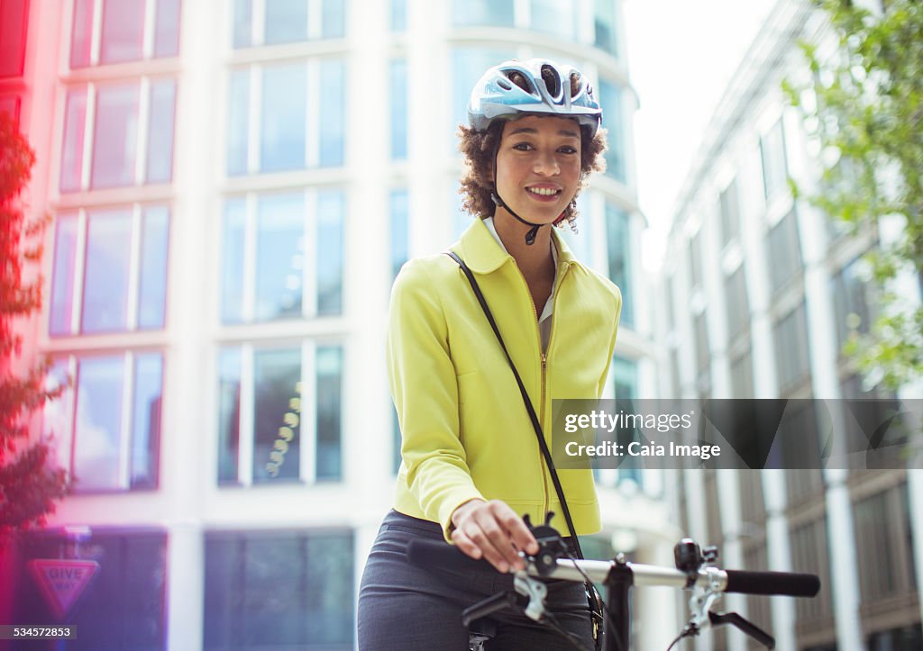 Businesswoman pushing bicycle in city