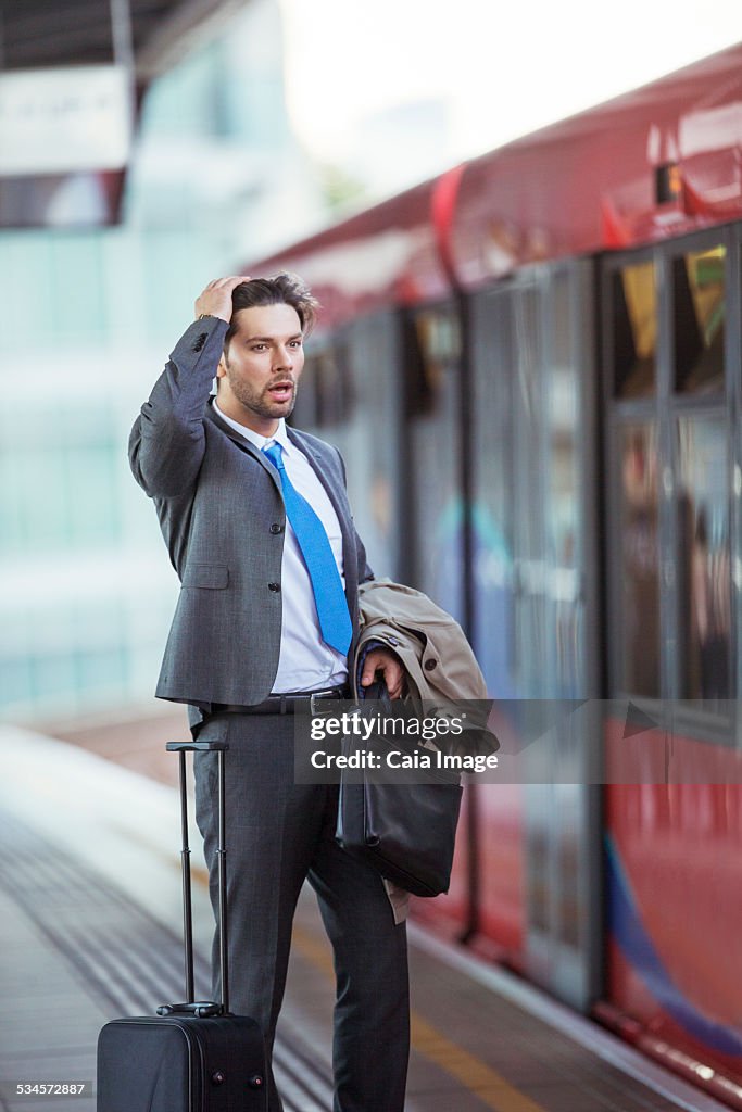 Frustrated businessman missing train in train station