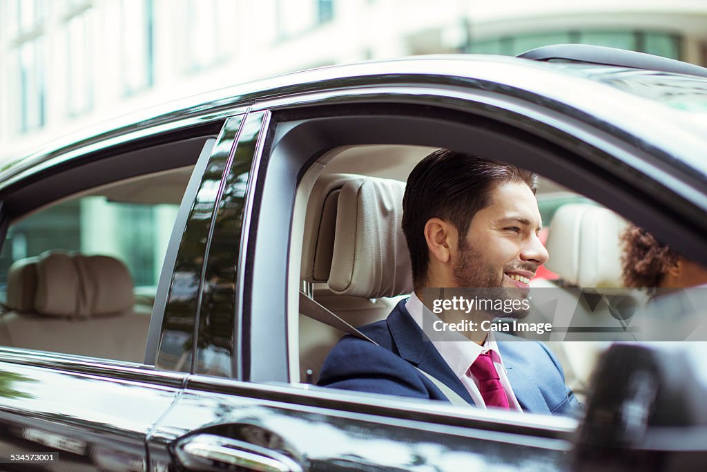 Businessman smiling in car