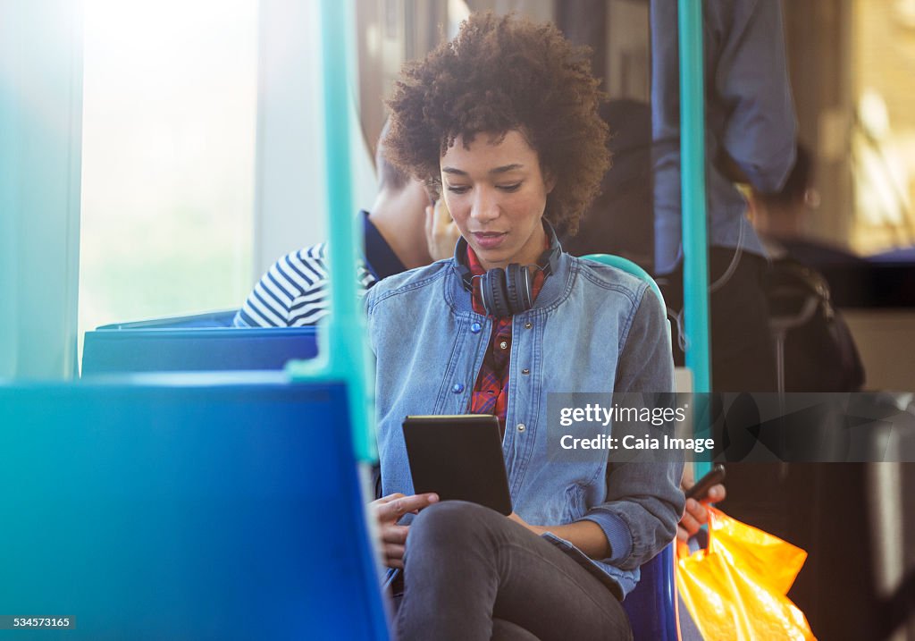 Woman using digital tablet on train