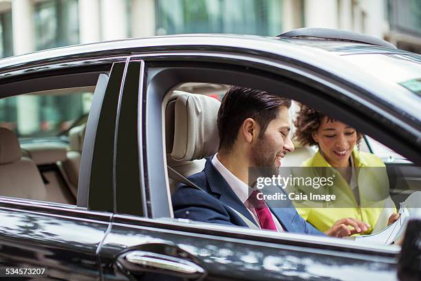 business people reading paperwork in car - man in car reading newspaper stock pictures, royalty-free photos & images