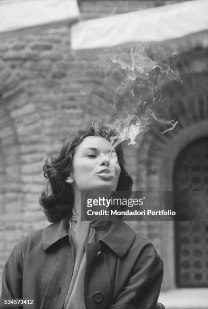 Smoke coming from Italian actress Lea Massari's mouth during the XVIII Venice International Film Festival. Venice, 1957