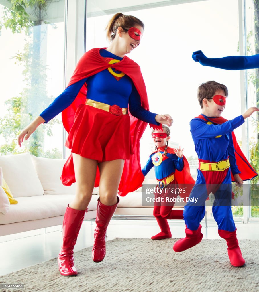 Family of superheroes playing in living room