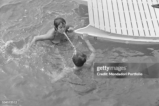 Italian actor Franco Interlenghi and his wife, Italian actress Antonella Lualdi , joking in the sea during the XVIII Venice International Film...