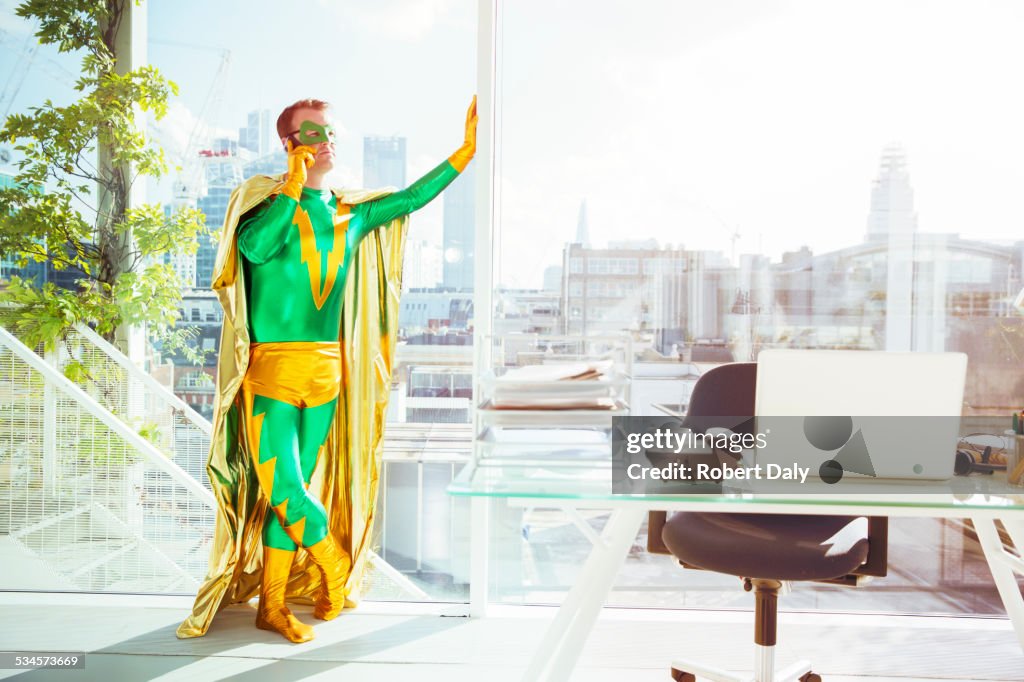 Superhero talking on cell phone in office