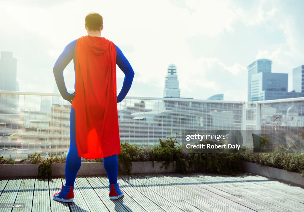 Superhero looking at view from city rooftop