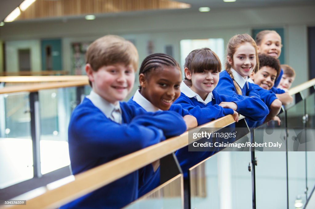 Portrait of elementary school children wearing blue school uniforms standing in school corridor