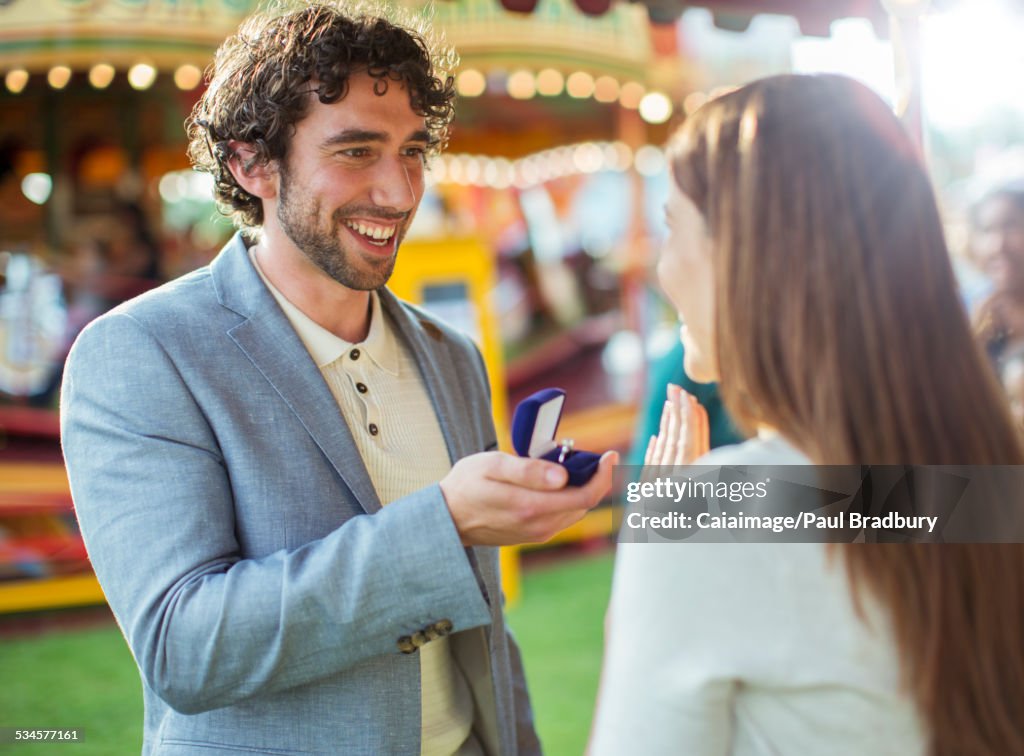 Mann, der seiner Freundin im Vergnügungspark einen Heiratsantrag macht