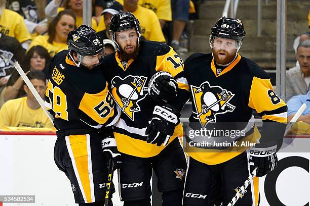 Nick Bonino of the Pittsburgh Penguins is assisted by tyeammates Kris Letang and Phil Kessel after being hurt during the third period against the...