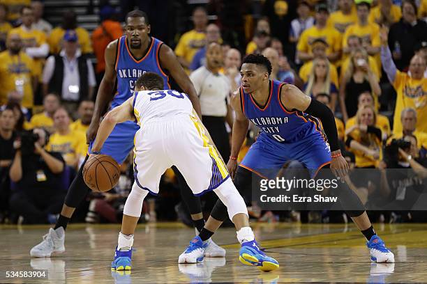 Kevin Durant and Russell Westbrook of the Oklahoma City Thunder defend against Stephen Curry of the Golden State Warriors during Game Five of the...