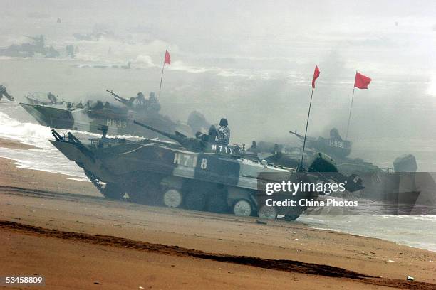 Amphibious tanks of the Chinese People's Liberation Army land on a beach during the third phase of the Sino-Russian joint military exercises August...