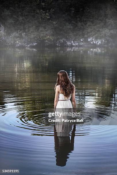 dreamy meditative woman in water - wading-through-river stock pictures, royalty-free photos & images