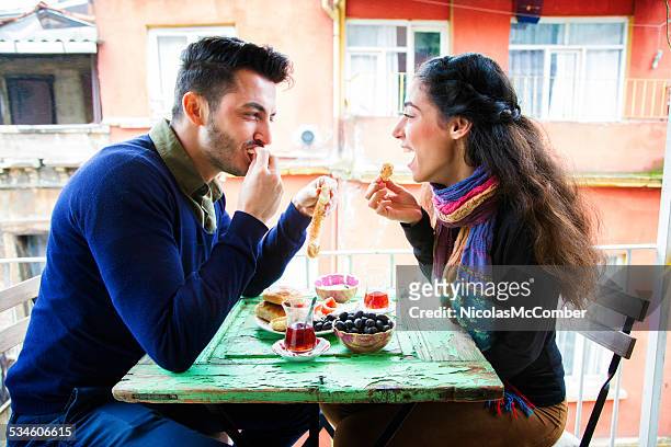 young middle eastern couple enjoying turkish snack on balcony - turkey middle east stockfoto's en -beelden