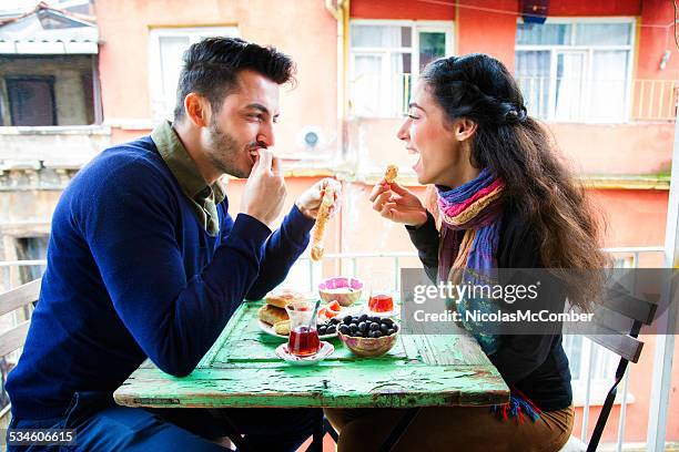 young middle eastern couple enjoying turkish snack on balcony - istanbul tea stock pictures, royalty-free photos & images