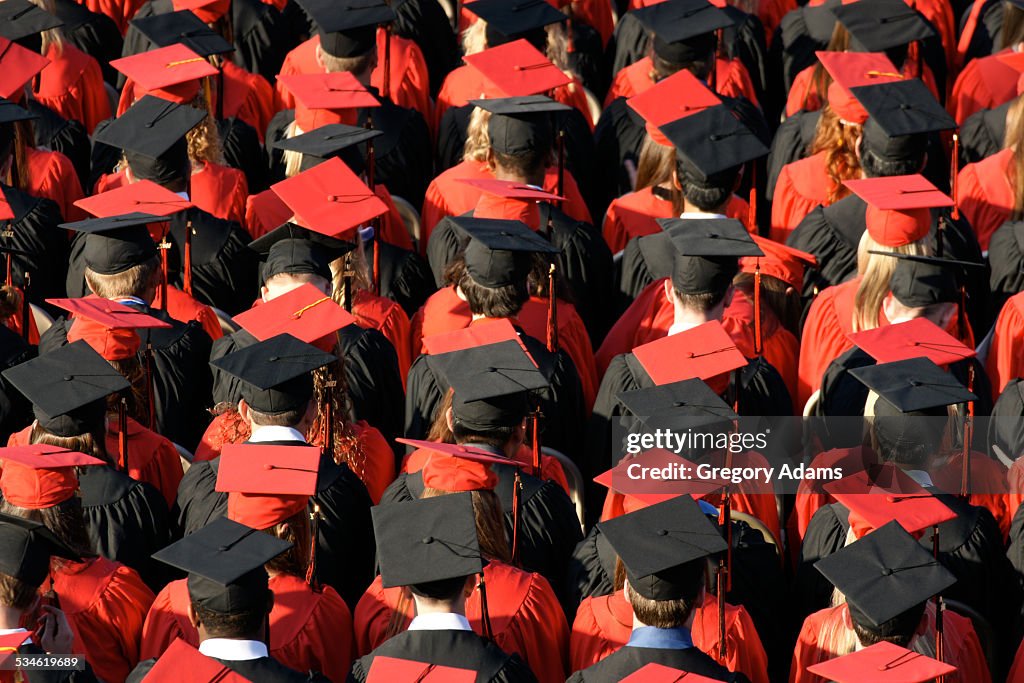 Graduates in red and black caps and gowns