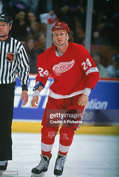 Canadian hockey player Bob Probert of the Detroit Red Wings, jersey on his hand, is escourted off the ice by an official after a fight at the...