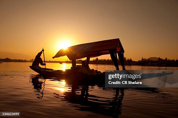 silhouette person rowing a boat - dalmeer stockfoto's en -beelden