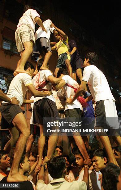 Indian devotees of Hindu God, Lord Krishna prepare to form a seven-tier human pyramid as they practise for "dahi-handi"- contest in Mumbai, late 25...