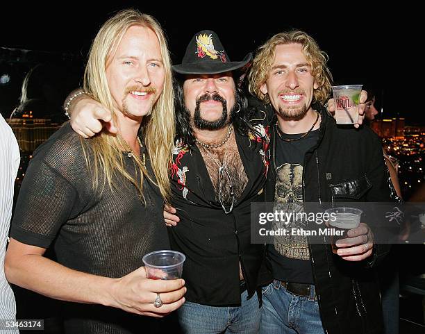 Guitarist Jerry Cantrell, former Pantera and Damageplan drummer Vinnie Paul and Nickelback frontman Chad Kroeger pose at a birthday party for Kiss...
