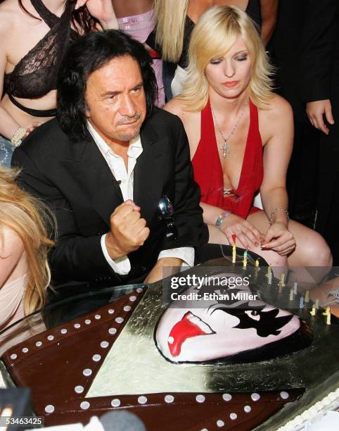 Kiss singer/bassist Gene Simmons pumps his fist after blowing out the candles on his birthday cake during his birthday party at the Ghostbar at the...