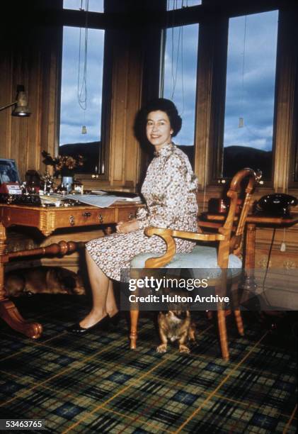 Queen Elizabeth II with her dogs in her study, 1972.