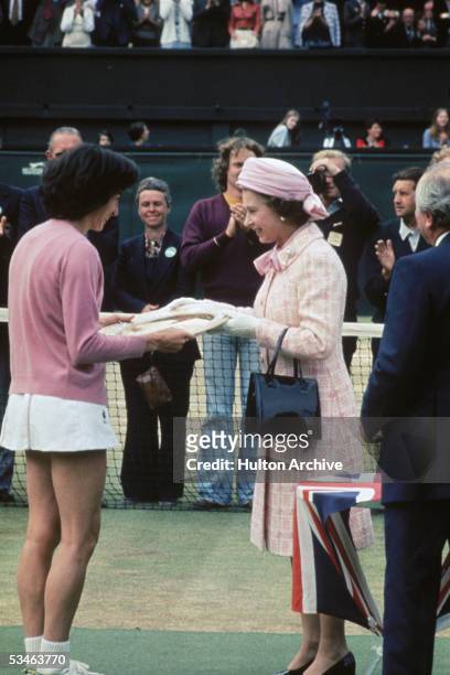 Queen Elizabeth II presents the trophy to British tennis player Virginia Wade after she won the Women's Singles competition at Wimbledon, 1st July...