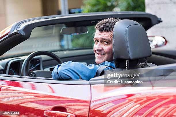 mature man driving his convertible car - medelålderskris bildbanksfoton och bilder