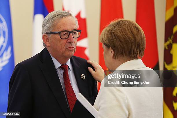 European Union Commission President Jean-Claude Juncker talks with German Chancellor Angela Merkel durng a "Outreach Session" on May on May 27, 2016...