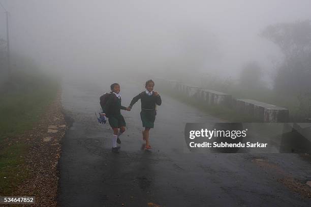 School children walk back home from school along a road in the mist covered Cherapunjee in Meghalaya. Cherrapunjee or Charrapunji is a subdivisional...